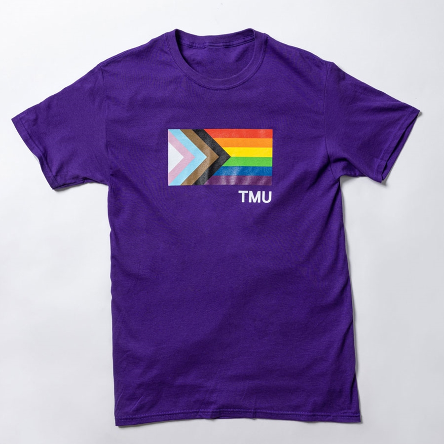 A  short-sleeved purple t-shirt features the Pride Progress flag with a small TMU in white.